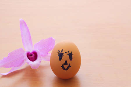 egg dall and Purple orchid on the wooden table