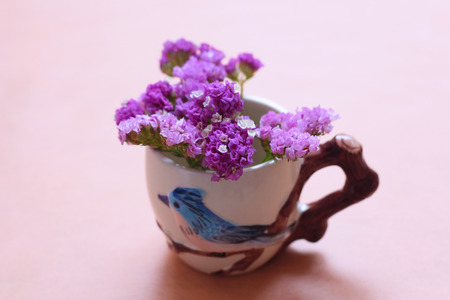 Purple flowers in a vase on the wooden tableの写真素材