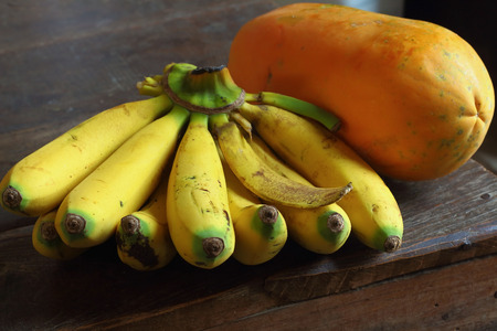 banana and papaya on the old wooden tableの写真素材