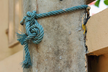 Blue rope tied to an electricity poleの写真素材