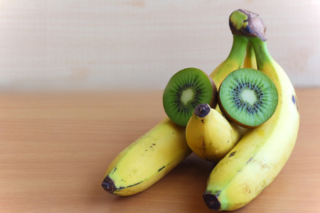 Banana and kiwi on the wooden tableの写真素材