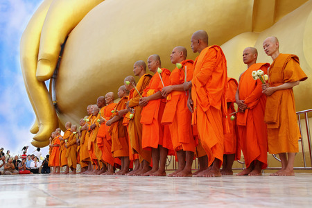 Ang Thong, Thailand-July 11,2014: Buddhists and monks walk with lighted candles clockwise round the temple, Asaha Puja Day and the beginning of Buddhist Lent, at Wat Muang- Ang Thong, Thailand.のeditorial素材