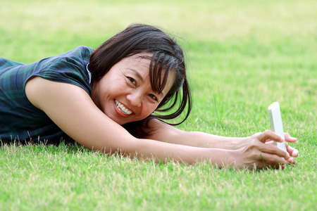 Asian women aged using touch technologyの写真素材