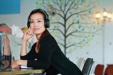 Asian woman listening music in shopの写真素材