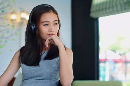 Asian woman listening music in shopの写真素材