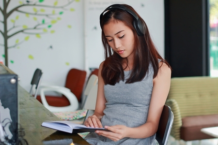 Asian woman listening music in shopの写真素材