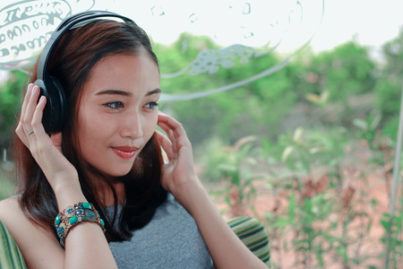 Asian woman listening music in shopの写真素材