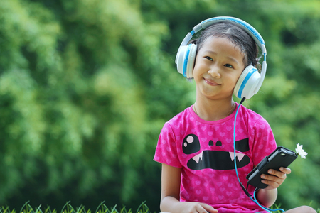Asian girl listening music in parkの写真素材