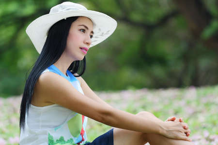 Portrait of a beautiful asian woman wearing a hat in the parkの写真素材