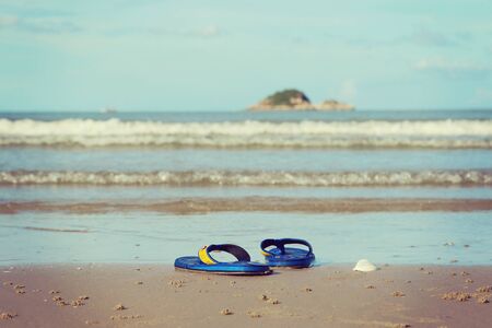 Sunglasses and shoes lay on the sand at the beach, vintage toneの写真素材