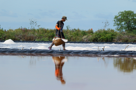 Phetchaburi, Thailand - September 9, 2015: Agriculture in Thailand, Workers working in the salt farm in Phetchaburi, Thailand.のeditorial素材