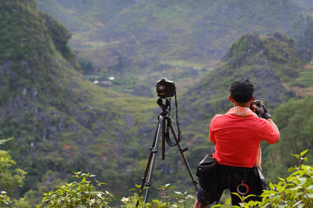 Asian man photographer take a photo at viewpoint, Rice terraces in Hagiang, Vietnamの写真素材