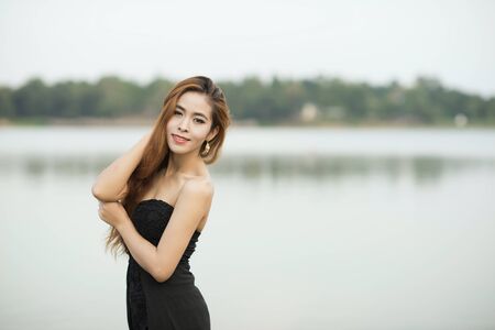 Portrait photography, Asian woman in a black dress looking at the camera.の写真素材