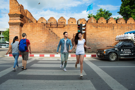 Chiang Mai, Thailand - September 15, 2016: Couple running across the crosswalk The Tha Pae gate in Chiang Mai, Tha Pae Gate in Chiang Mai is a place where history is in the past: the inner city of Chiang Mai.のeditorial素材