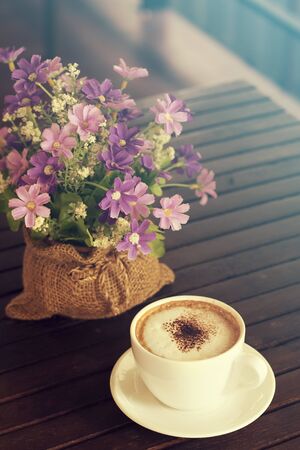 Cappuccino, Hot coffee cup on a wooden table, vintage tone and soft focusの写真素材