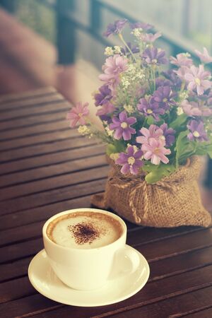 Cappuccino, Hot coffee cup on a wooden table, vintage tone and soft focusの写真素材
