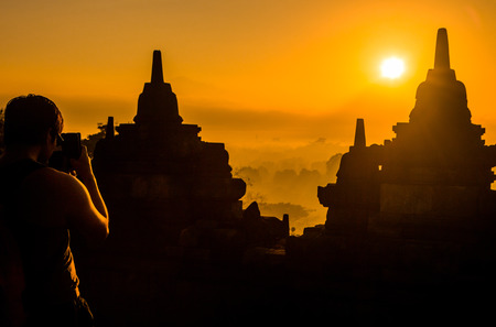Tourists waiting for the sunset and take a picture by smart phone at Borobudurの写真素材