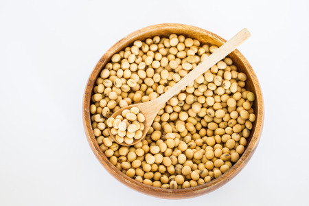 Soybeans on wooden spoon in a wooden bowlの写真素材