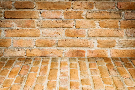 grunge background, red brick wall texture bright plaster wall and blocks road sidewalk abandoned exterior urban background for your concept or projectの写真素材