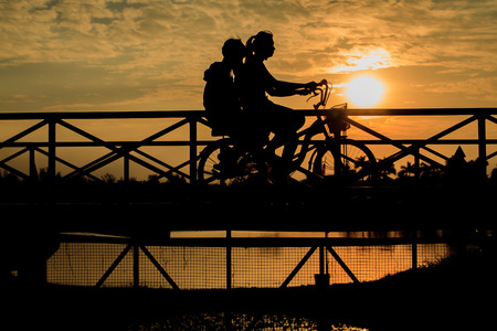 silhouette of biker on Bridge at sunsetの写真素材