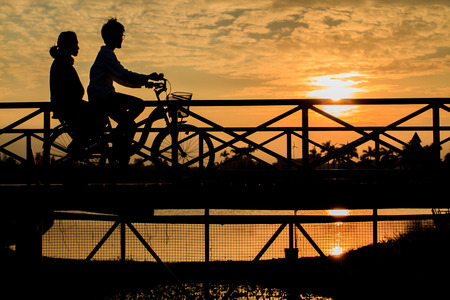 silhouette of biker on Bridge at sunsetの写真素材
