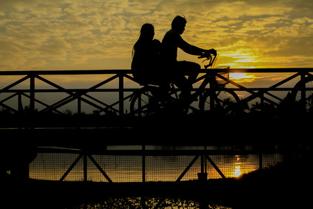silhouette of biker on Bridge at sunsetの写真素材