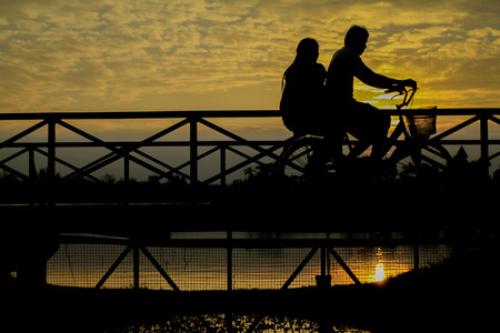 silhouette of biker on Bridge at sunsetの写真素材