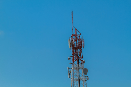 Close up white color antenna repeater tower on blue skyの写真素材
