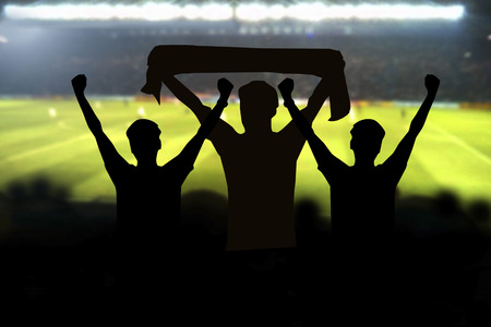 silhouettes of Soccer fans in a match and Spectators at football stadiumの写真素材