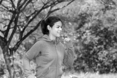 Running woman. Female runner jogging during outdoor on road .Young mixed race girl jogging in fall...