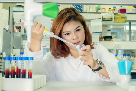 Young female tech or women asia scientist working with multichannel pipette in biological...