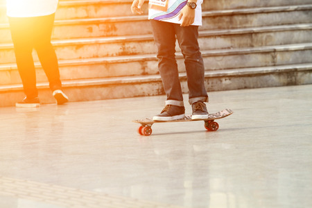 blurry Skateboarder doing a skateboard trick and Legs in sneakers on a skateboard