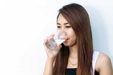 Portrait of young beautiful woman asia drinking water at summer and holding bottleの写真素材