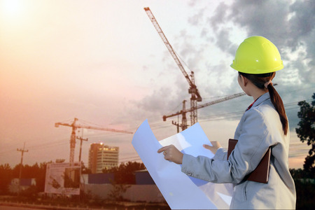 portrait women asia engineer working and holding blueprints at construction siteの写真素材