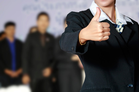 Business woman and business people thump up hand sign on business people background.の写真素材