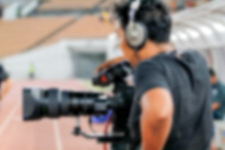 blurry of Professional cameraman and Video camera operator working with his professional equipmentの写真素材
