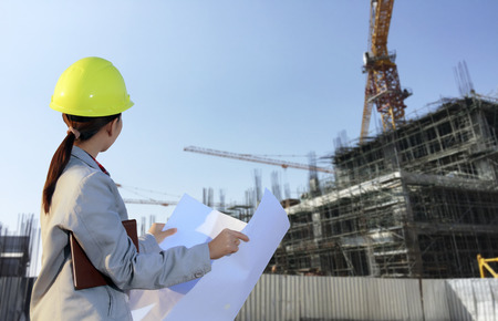 portrait women asia engineer working and holding blueprints at construction siteの写真素材