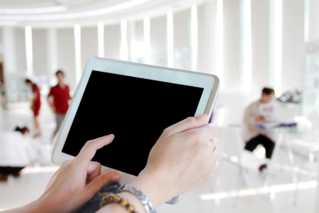 Blurry of asia women using tablet and businesswomen using touch pad on business people in office backgroundの写真素材