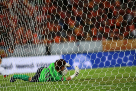 blurry goalkeeper jumps and blocks and Football(soccer) goalkeeper protecting the ballの写真素材