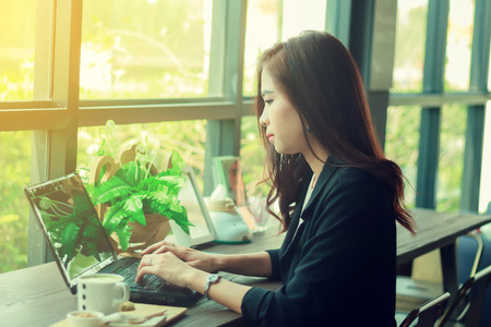 Asian business women using notebook and serious about the work ,soft focusの写真素材