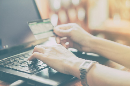 woman asian using laptop and credit card shopping online , selective focus on hand