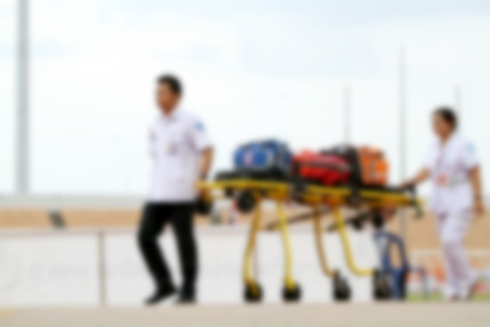 blurry doctor and ambulance car stand by at football stadium for helpの写真素材