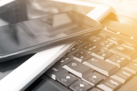 Closeup picture of a keyboard with a phone and tablet,vintage tone