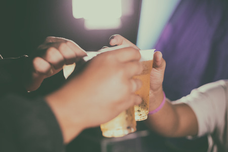 happy male friends drinking beer and clinking glasses ,soft focus and selective focus on hand 