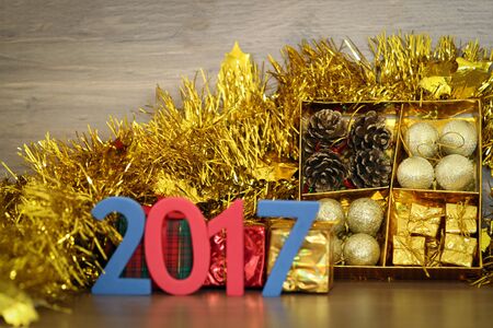 decorations and gift boxes on wooden board with Christmas and 2017 happy new year background