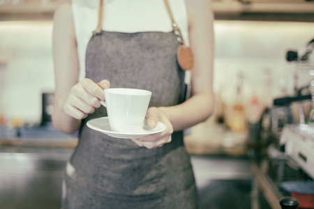 Asian women Barista holding a cup of coffee - Working woman small business owner food and drink cafe conceptの写真素材