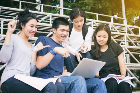 Asian Group of students sharing with the ideas for working on the campus lawnの写真素材