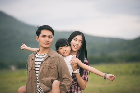 Happy family having fun and enjoying journey in the park at the sunset timeの写真素材