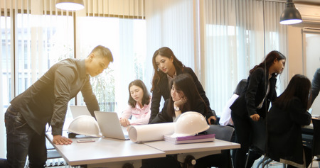Asian businessmen and group using notebook for meeting and business women smiling happy for workingの写真素材