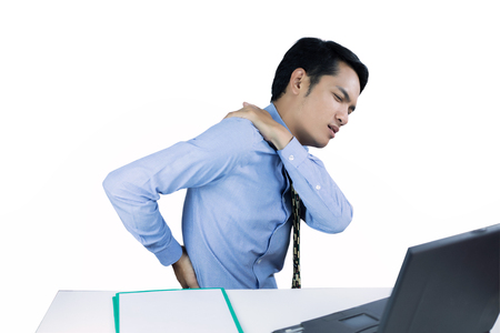 Asian Business men with back pain sin an office and serious about the work done until the headache on working hardの写真素材